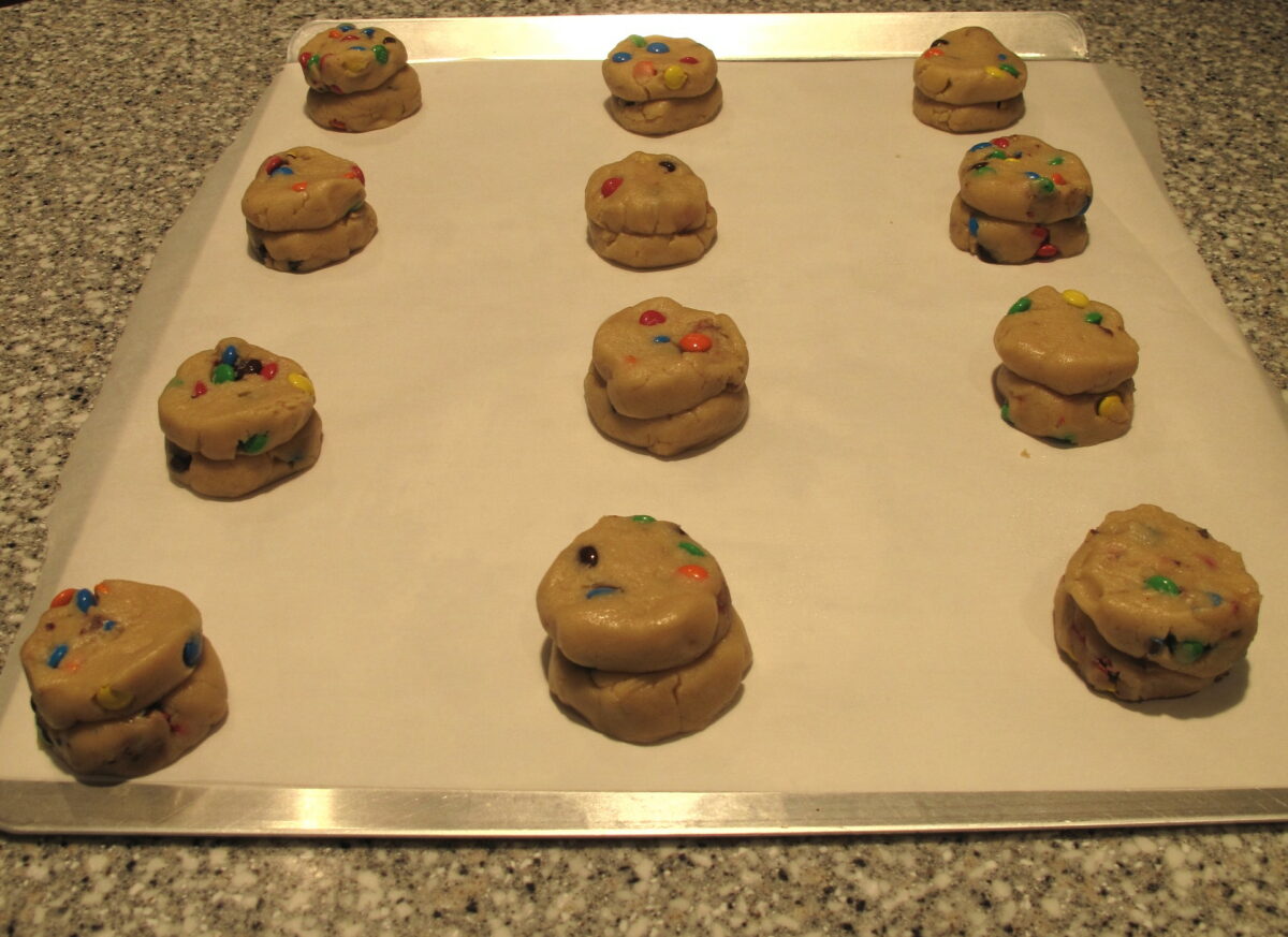 Dough ball stacks pressed slightly on a parchment lined cookie sheet.
