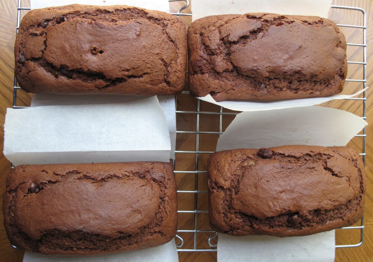 Four chocolate mini loaves on a metal cooling rack.