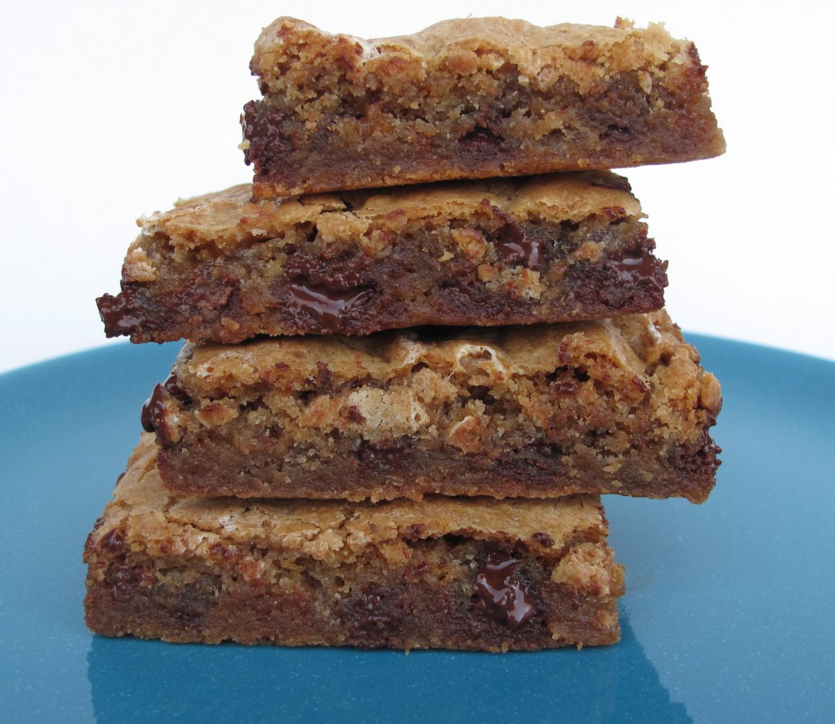 Stack of Chewy Chocolate Toffee Marshmallow Cookie Bars on a blue plate.