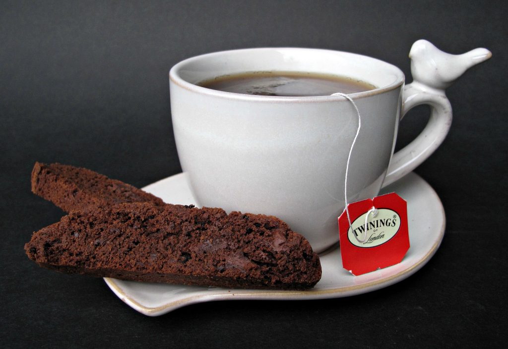 Chocolate Espresso Biscotti on the edge of a sauce with a cup of tea.