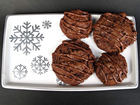 Cookies with milk chocolate zigzags on top on a white serving tray.