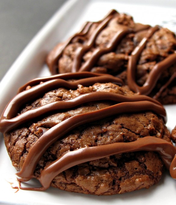 Closeup of a brownie cookie with melted chocolate lines on top.