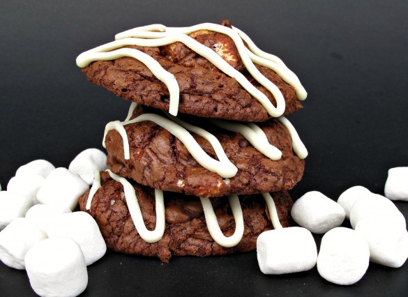 Stacked cookies with marshmallows on a black background.