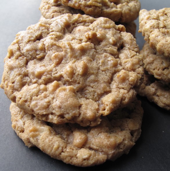 Close up of two stacked cookies, bumpy on top from bits of toffee inside.