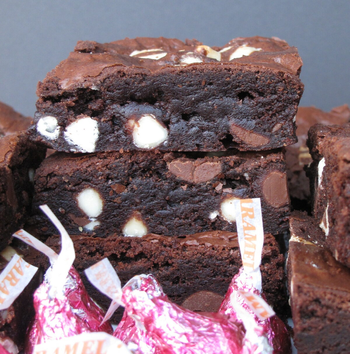 Closeup of cut edges of two stacked brownies with white and milk chocolate chips inside.