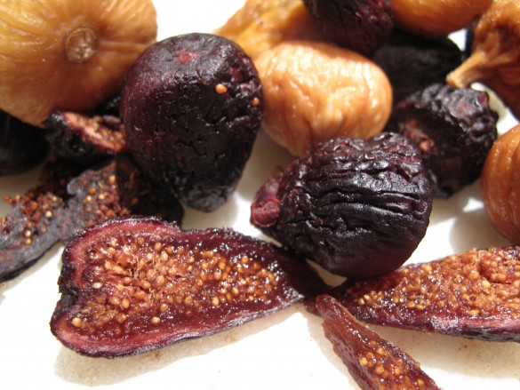 Yellow and purple dried figs with on cut open showing seeds.