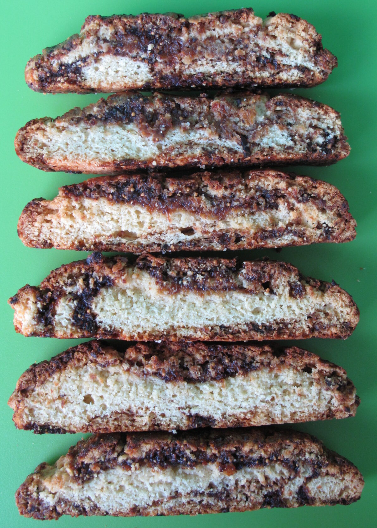 Biscotti lying on their cut edge to show the ribbons of jam inside.