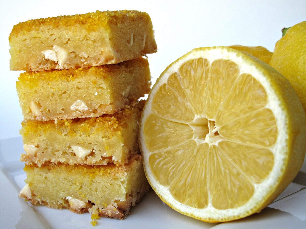 A stack of lemon bars next to a lemon half.