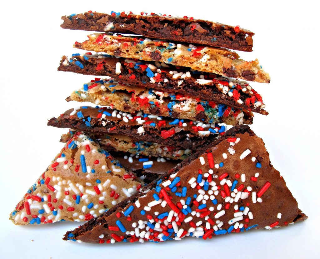 Stack of thin crunchy cookie-brittle in chocolate chip or brownie flavors, sprinkled with red, white and blue jimmies!