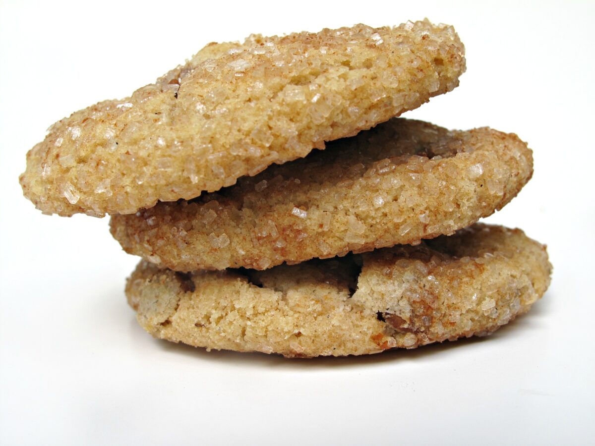 Stack of three sugar coated cookies showing rounded edge.