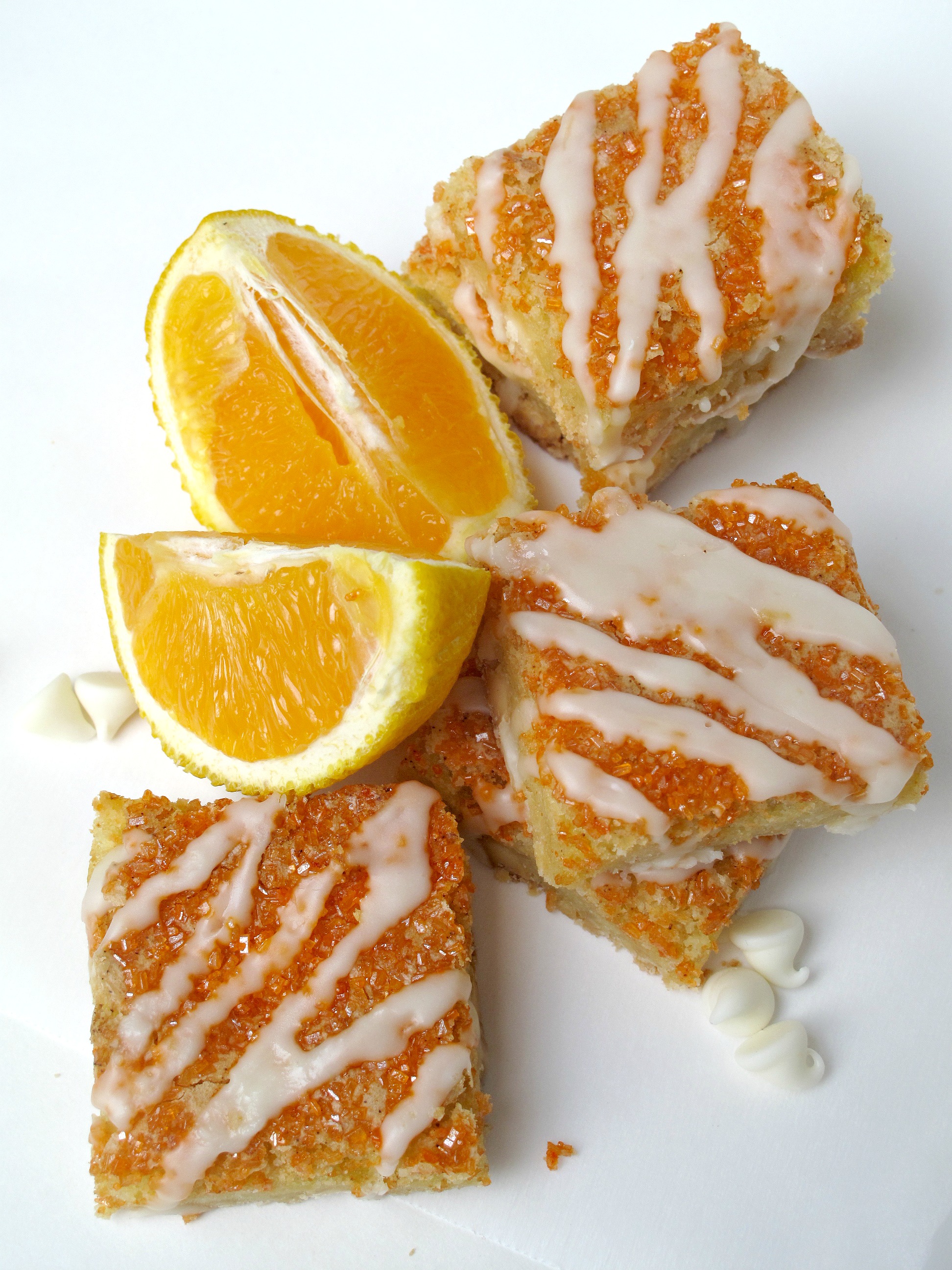 Orange Bars topped with orange sugar and icing zigzags with cut oranges.
