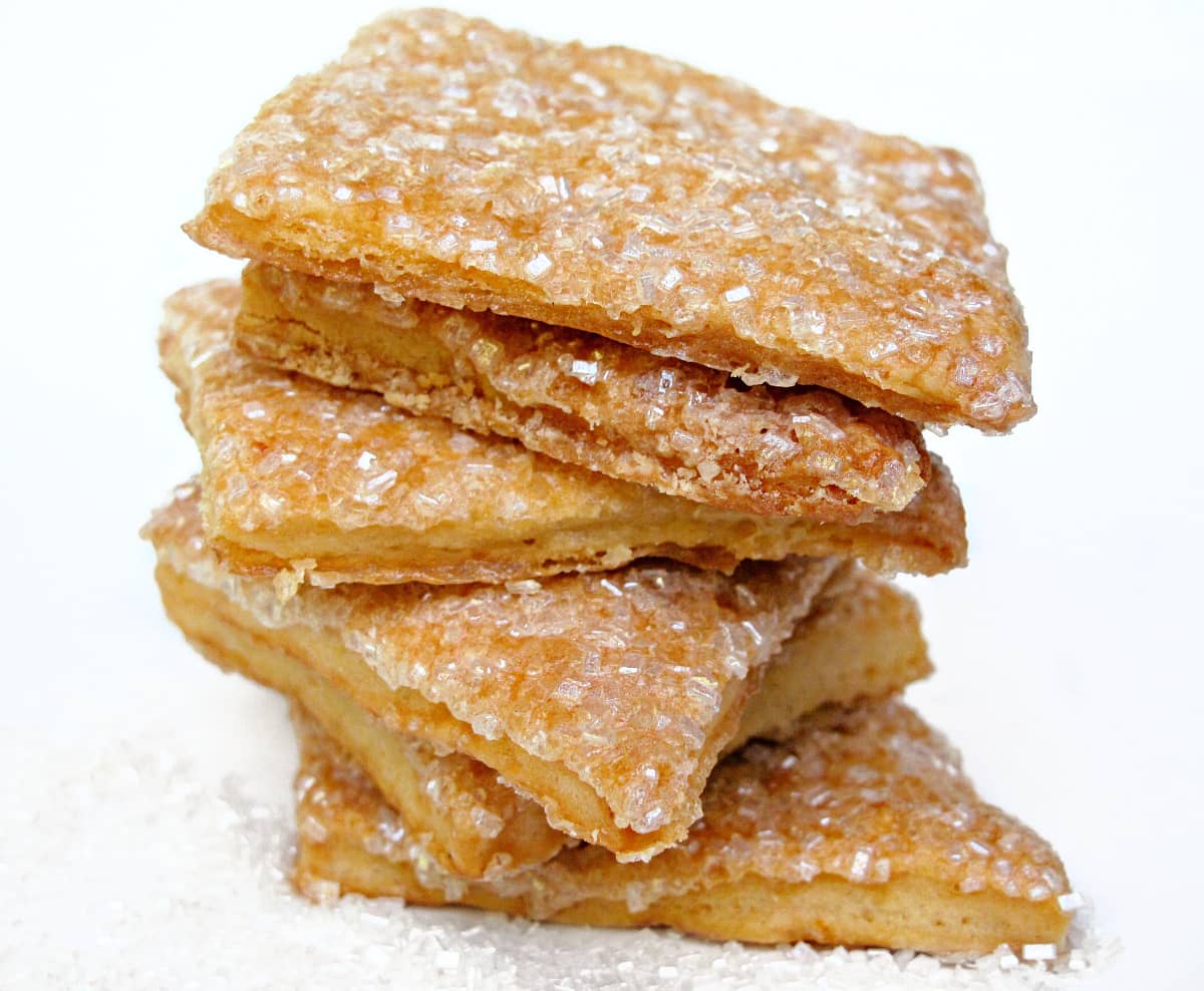 Stack of sugar coated square cookies with thin edges.