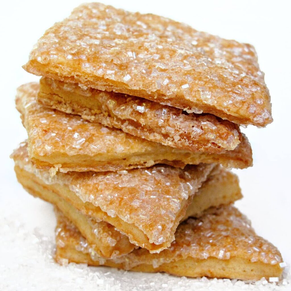 Stack of maple crisp cookie pastry squares coated in large crystal sugar.