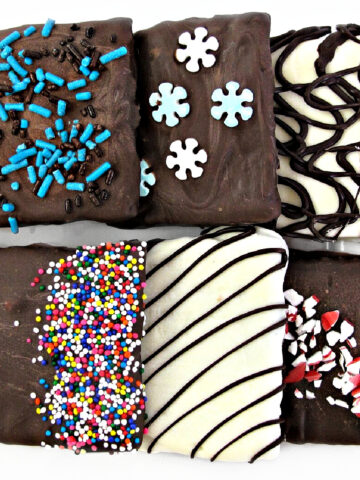 Chocolate covered graham crackers decorated with sprinkles and drizzle.