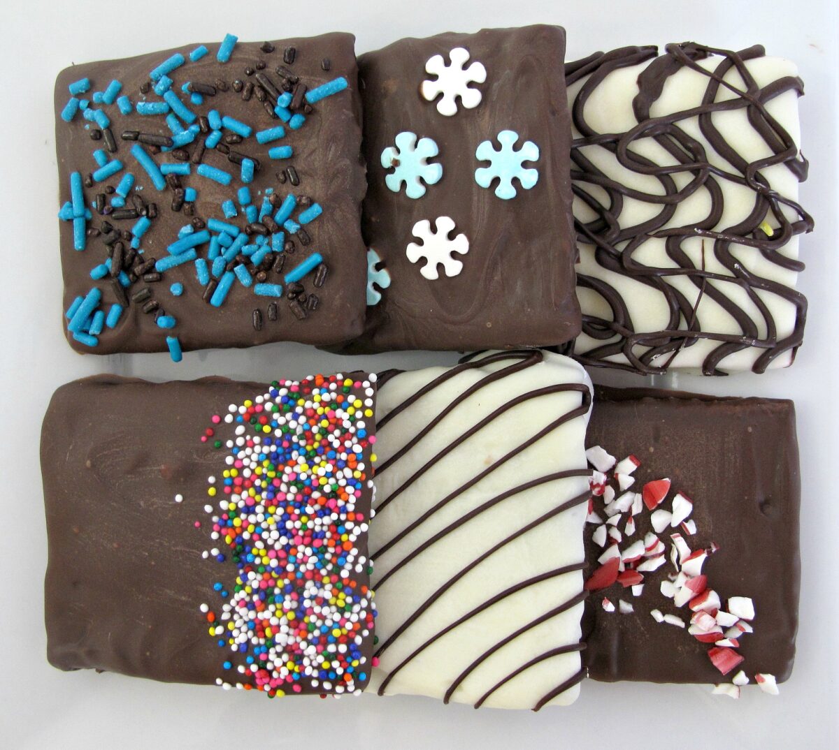 Chocolate Covered Graham Crackers decorated with sprinkles or drizzle.