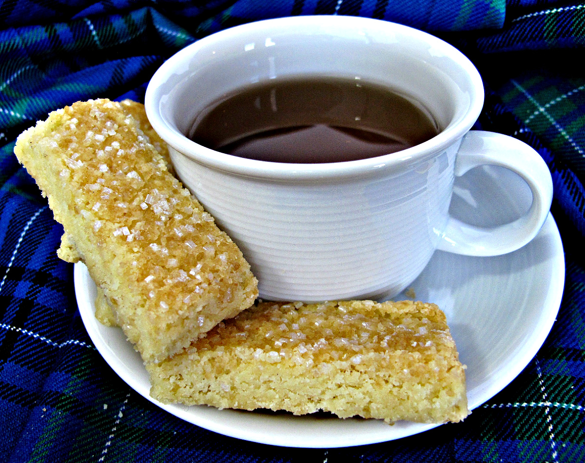 Two rectangles of Scottish Shortbread on a saucer with a tea cup.
