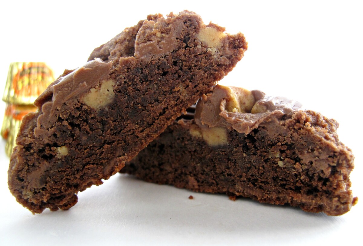 Closeup of Chocolate Peanut Butter Cup Cookie cut in half to show thick, dense interior.