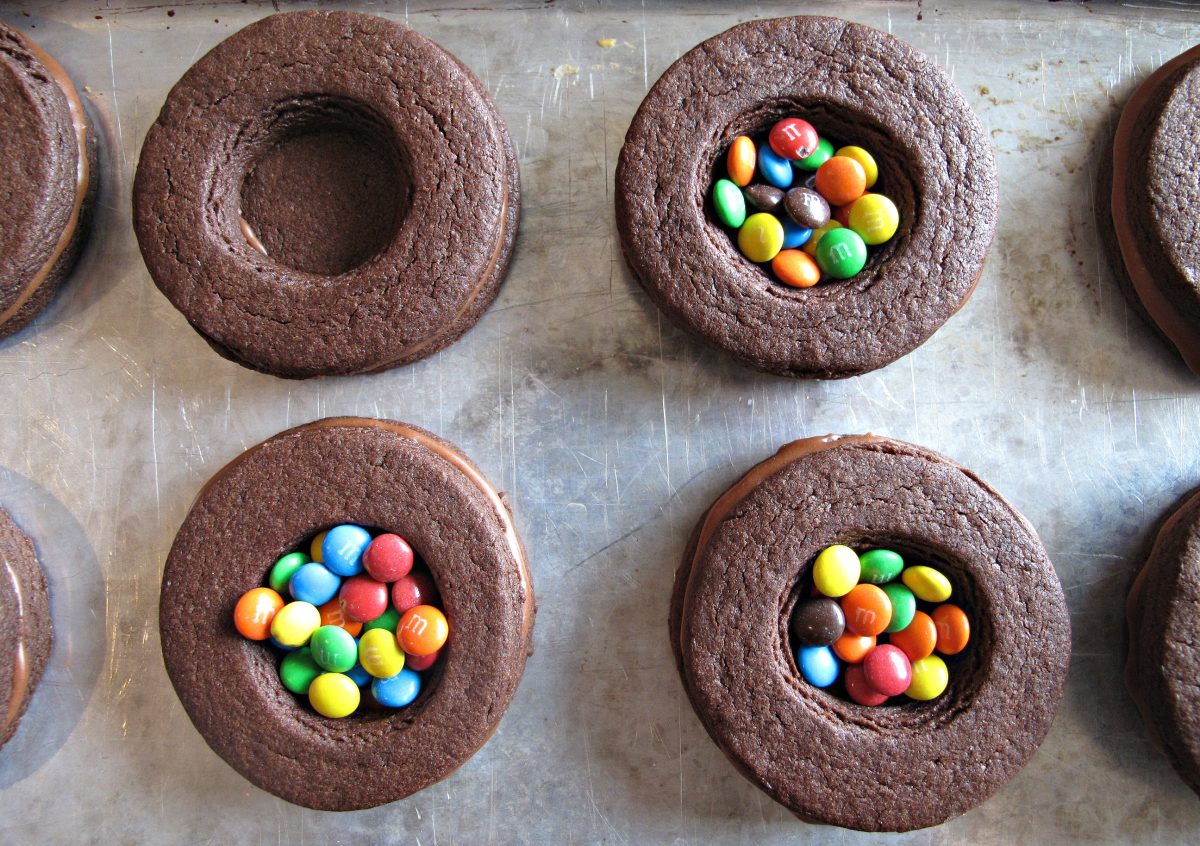 Stacked chocolate sugar cookie circles with middle  cookie center hole filled with mini m&m's.  