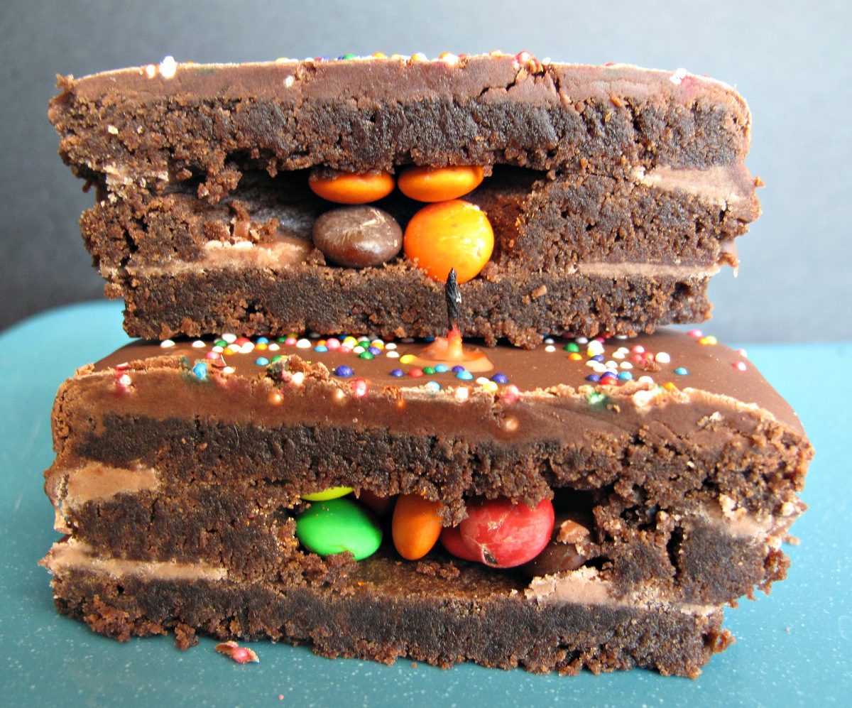 Chocolate cookie cut in half showing three layers and candy center.