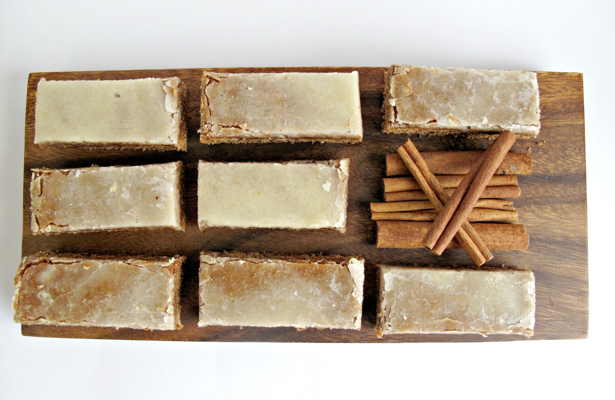 Overhead view of iced Lebkchen bars with a pile of cinnamon sticks.