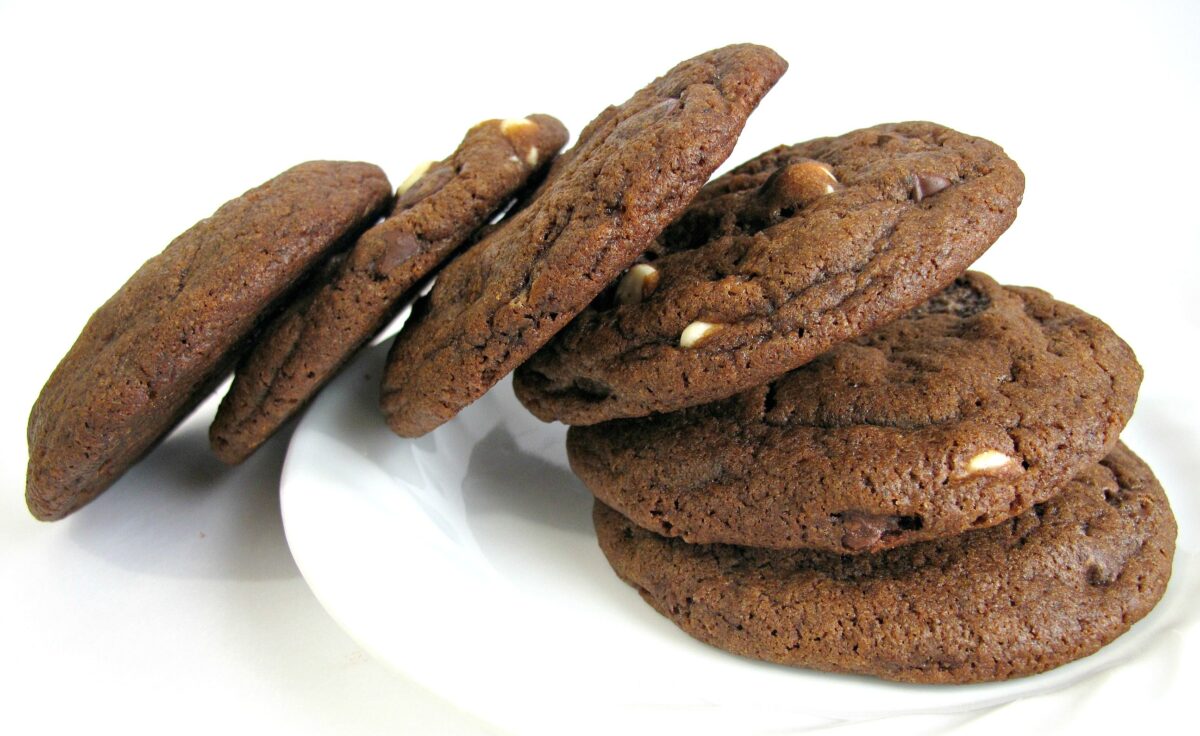 Thick chocolate cookies stacked on a white plate.