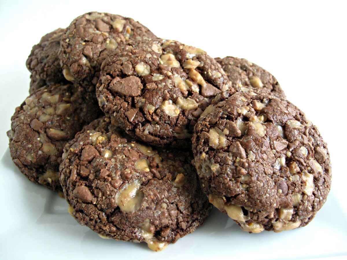Soft Chocolate-Toffee Cookies in a pile, each coated with bits of toffee.