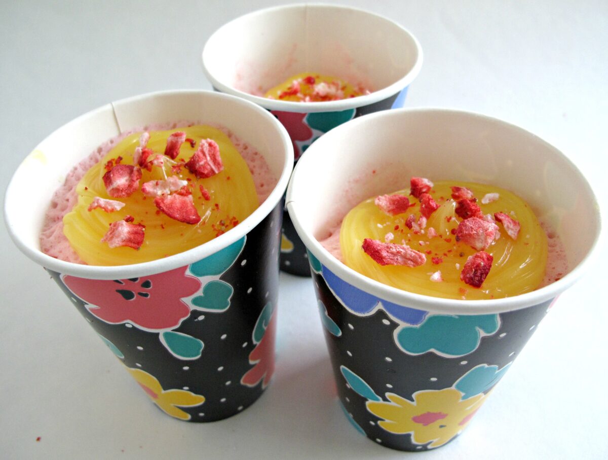 Individual Strawberry Lemonade Cakes topped with lemon curd, microwaved in flowered paper cups.