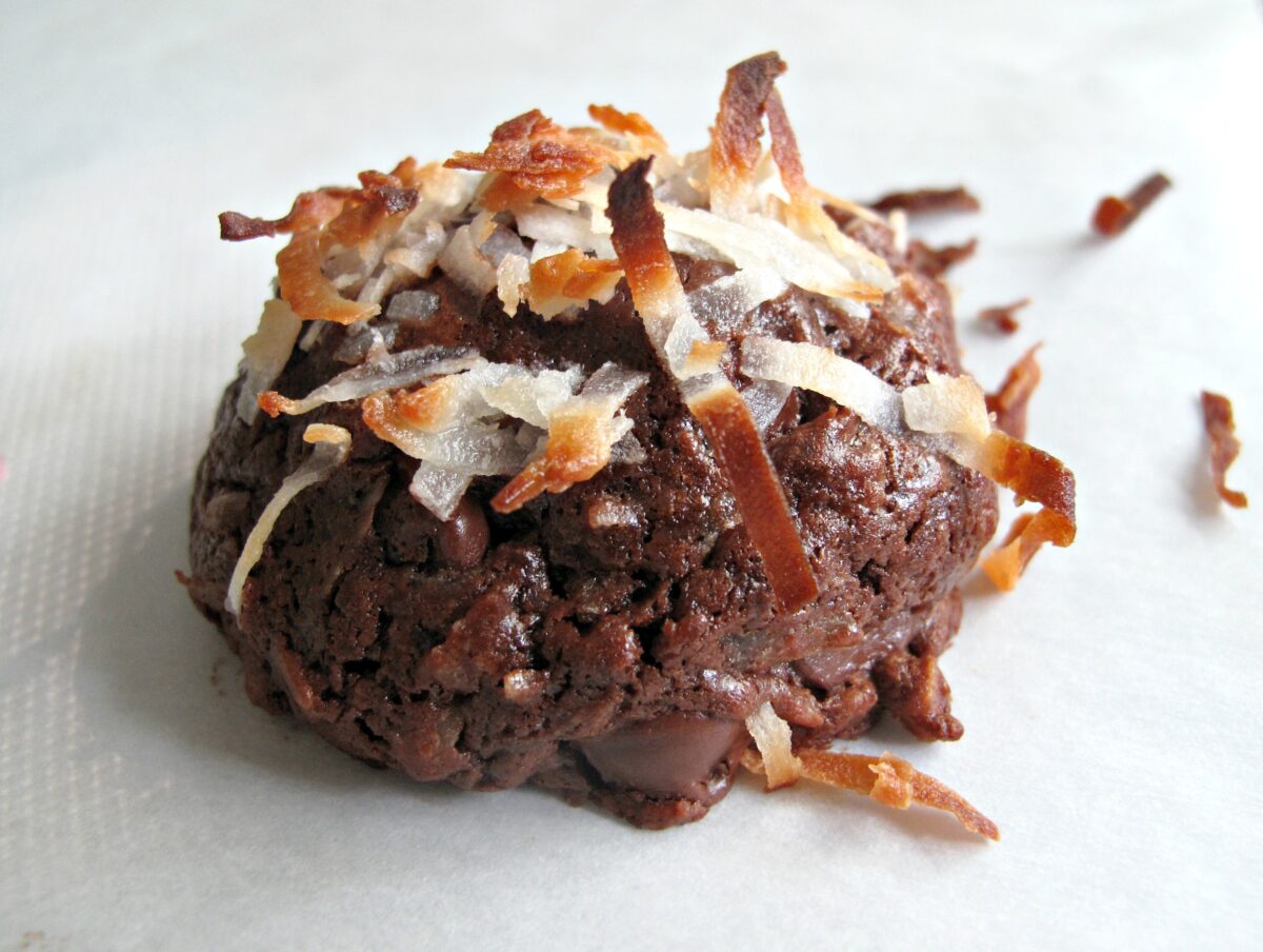 Closeup of a ball shaped chocolate coconut cookie topped with shredded coconut.