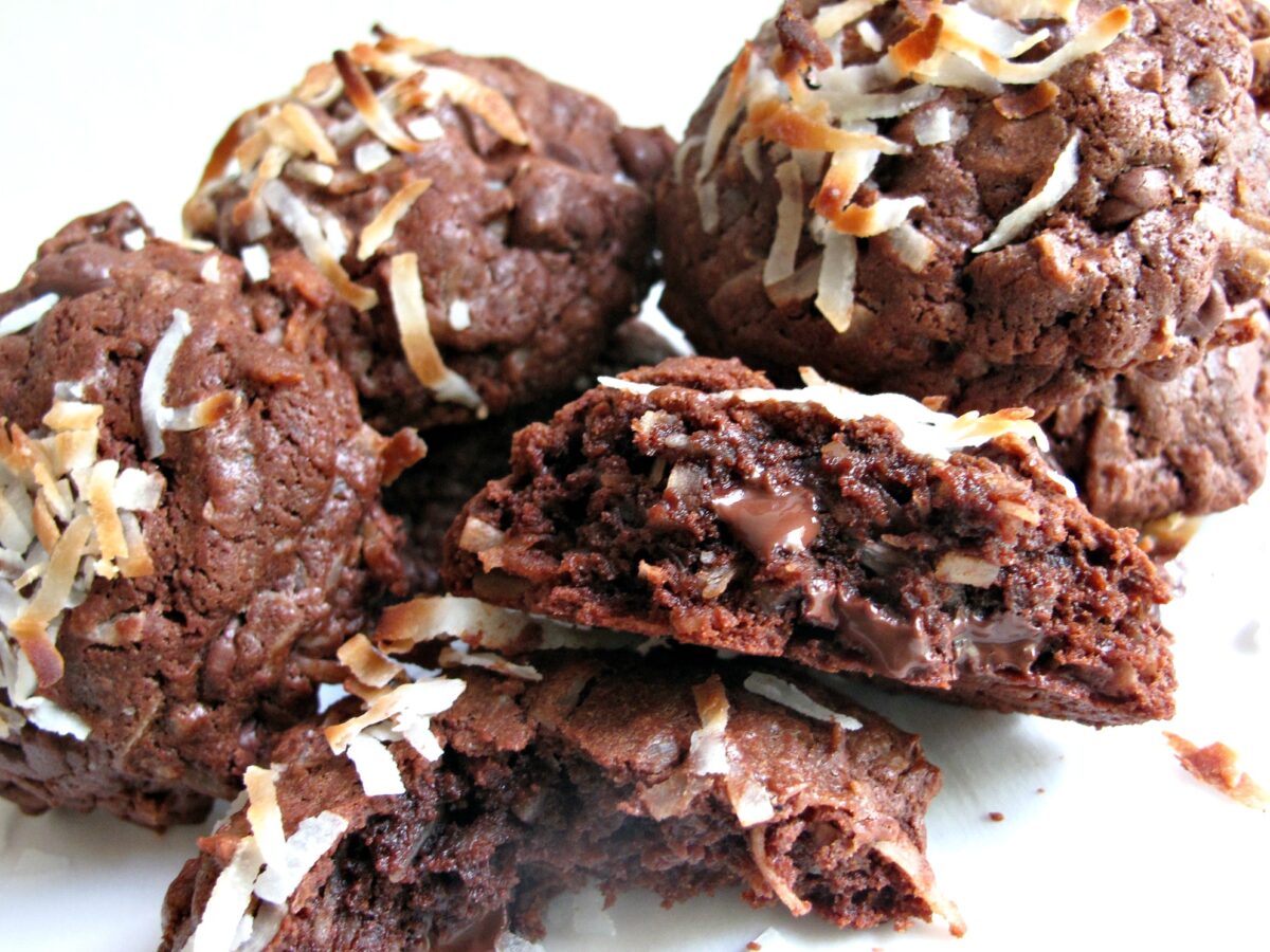 Inside of chocolate coconut cookie showing melted chocolate chips, dark chocolate dough, and shredded coconut.
