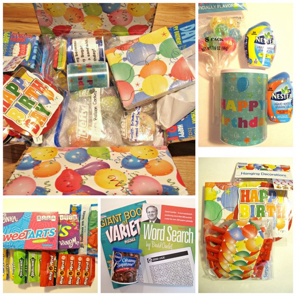 Birthday Care Package contents. The box interior is lined with balloon print paper. The contents include a faux birthday candle, balloon lollipops, drink flavoring drops, candy, puzzle books, and happy birthday plates and napkins.