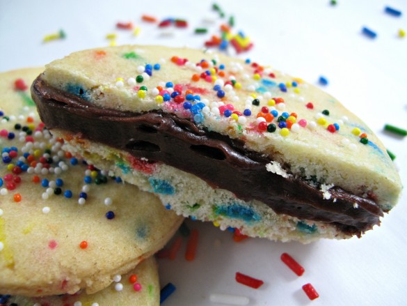 Cut open cookie showing the cookie on top and bottom and the layer of frosting in the middle.