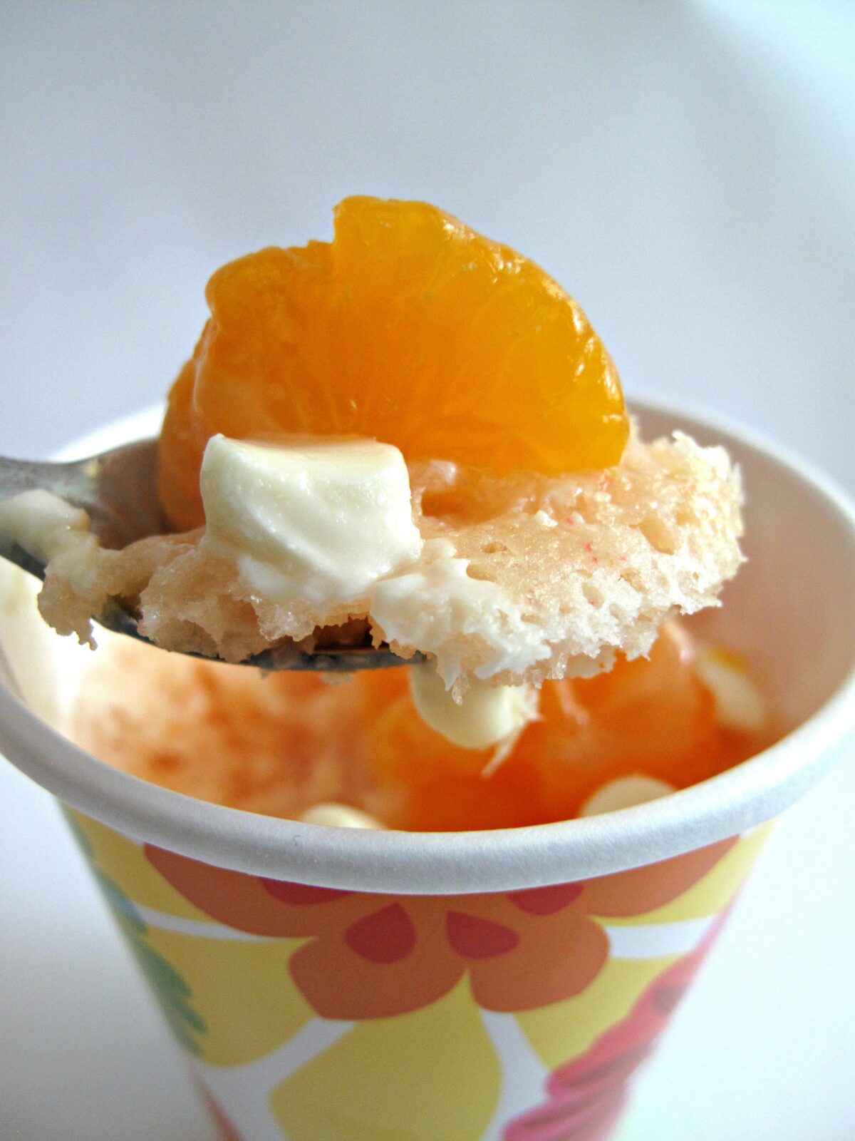 Closeup of spoonful of mug cake with an orange segment.