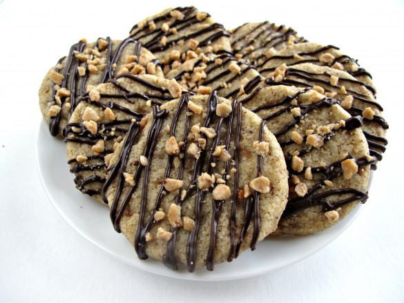 Plate of Espresso Toffee cookies with drizzle of chocolate and bits of toffee on top.