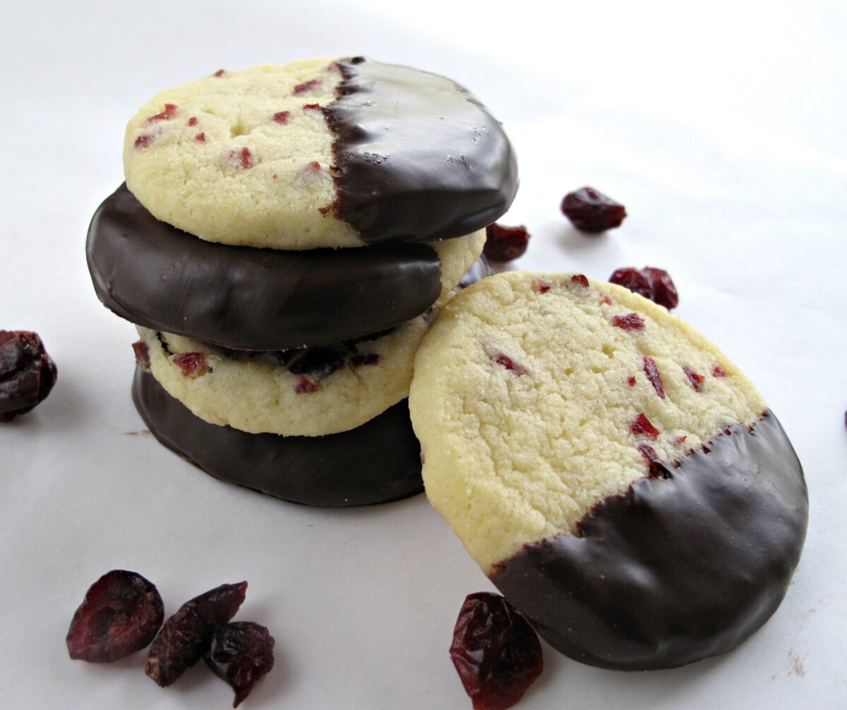 Stack of Cranberry Orange Slice-and-Bake Shortbread half dipped in chocolate.