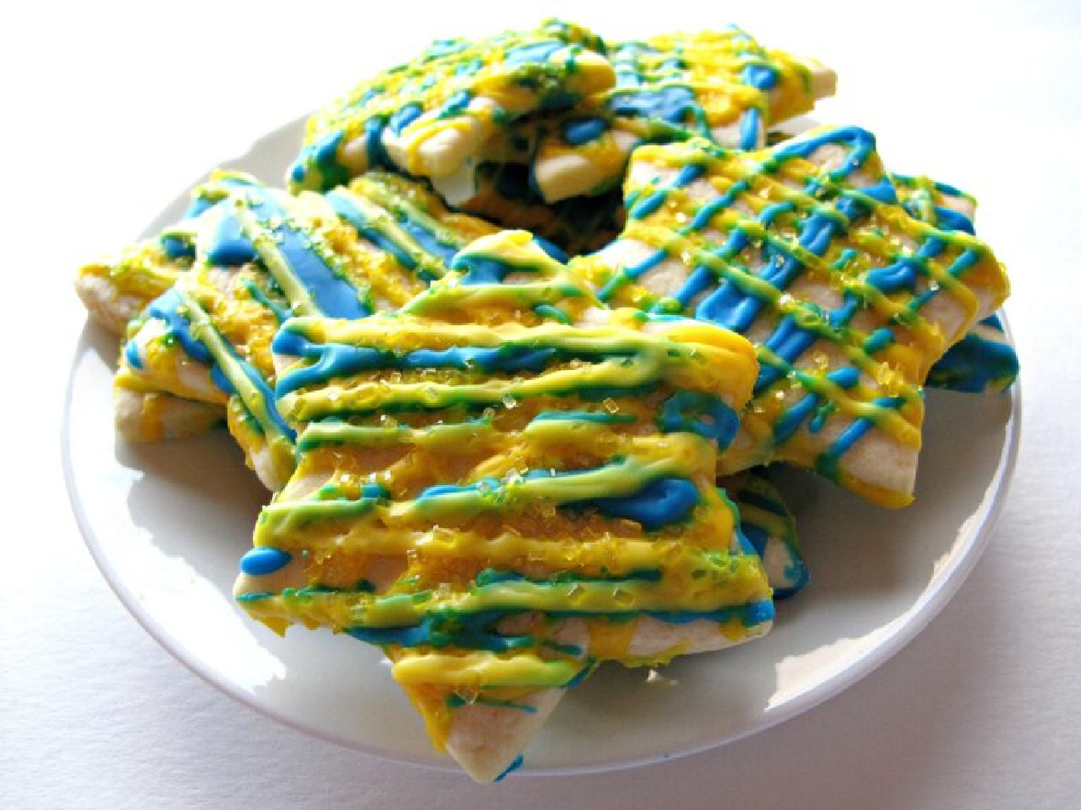 Lemon star cut-out cookies with yellow and blue zigzags of lemon icing.