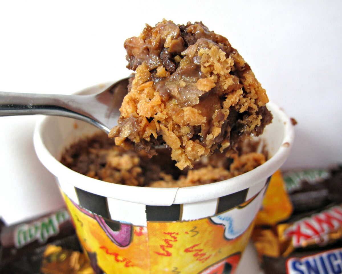 Candy Bar Mug Cake on a spoon with chocolate cake and candy bits.