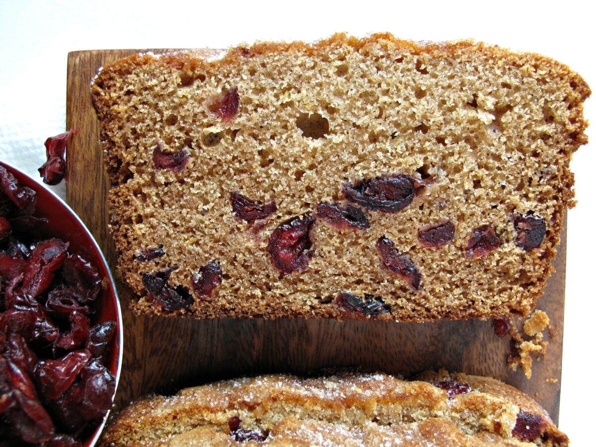 One slice of Cranberry Clementine Whole Wheat Quick Bread showing interior of loaf studded with cranberries