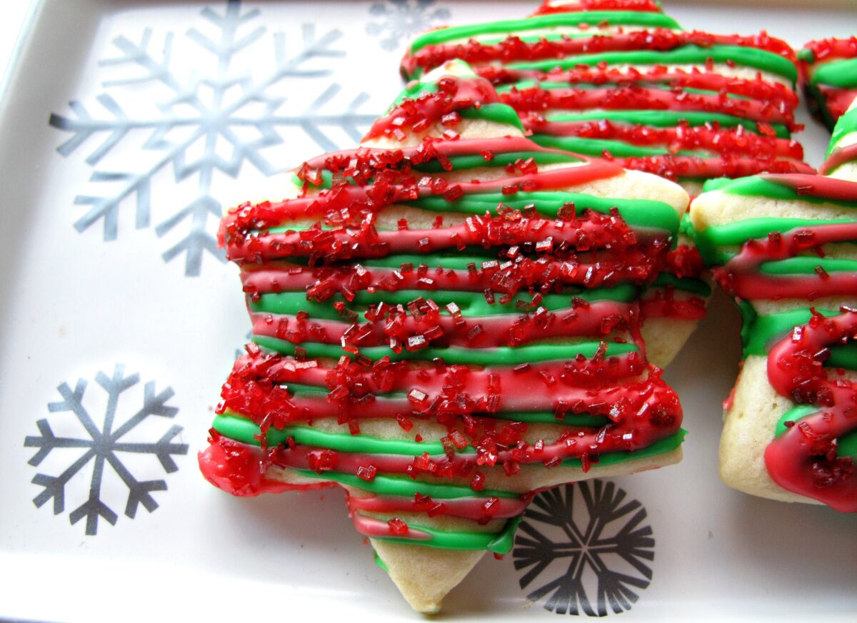 Closeup of star cookie with red and green zigzag icing and red sugar.
