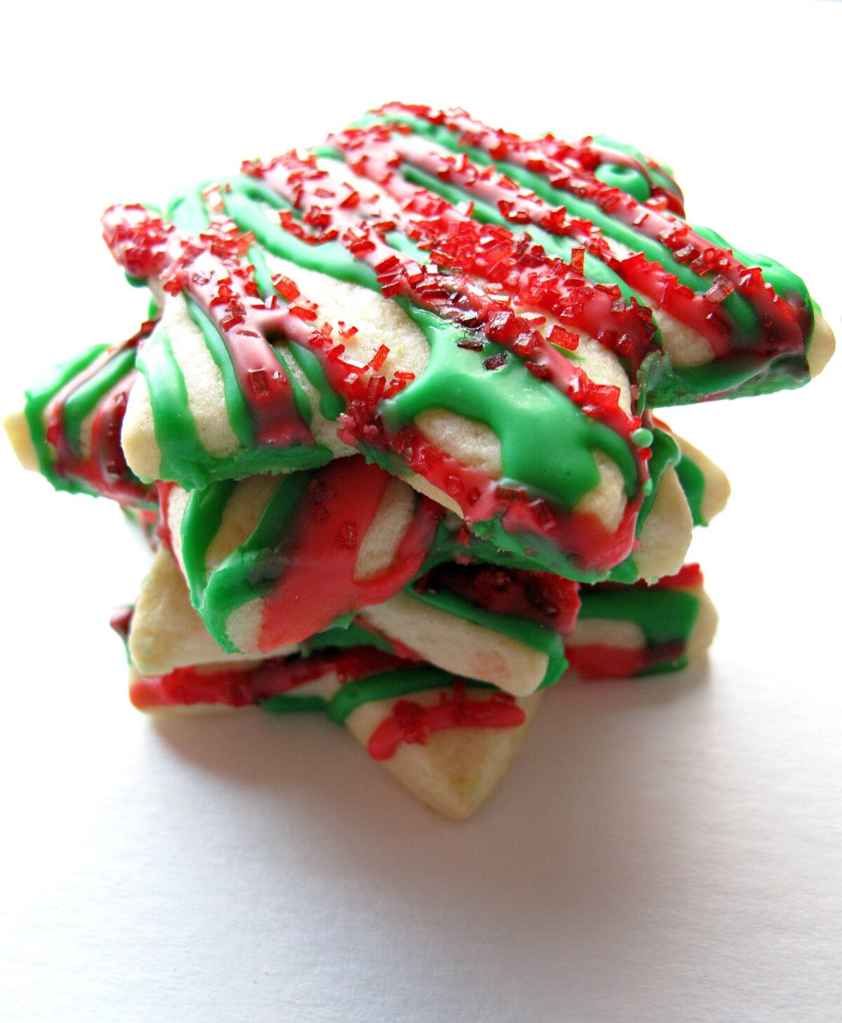 Stack of star cookies with red and green icing zigzags.