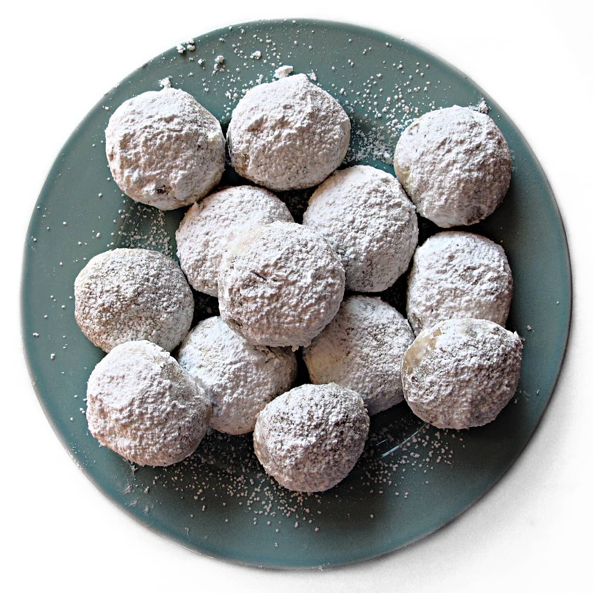 Round ball shaped cookies coated in powdered sugar.