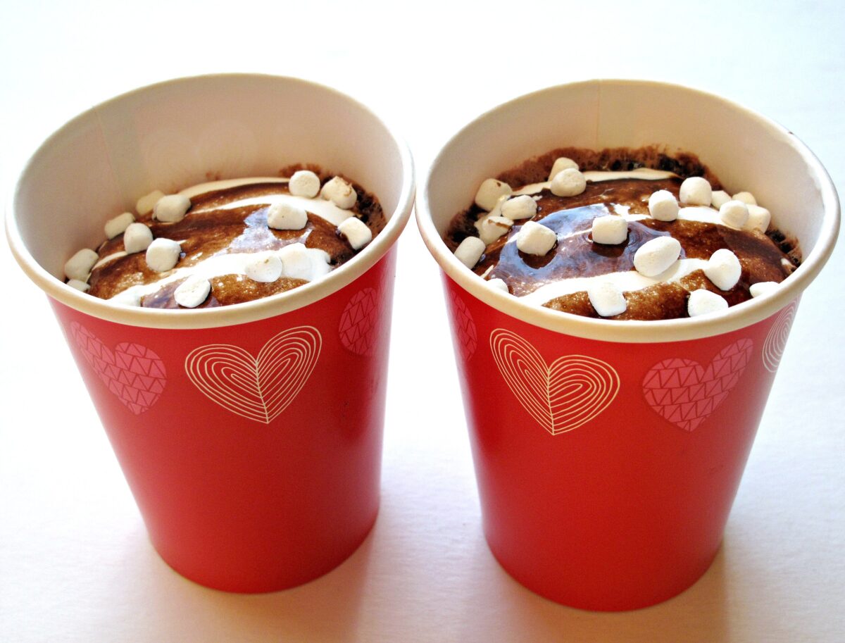 Hot Chocolate Mug Cake topped with mini marshmallows in 2 red paper cups.