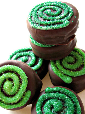 chocolate covered oreos with green swirls on top.