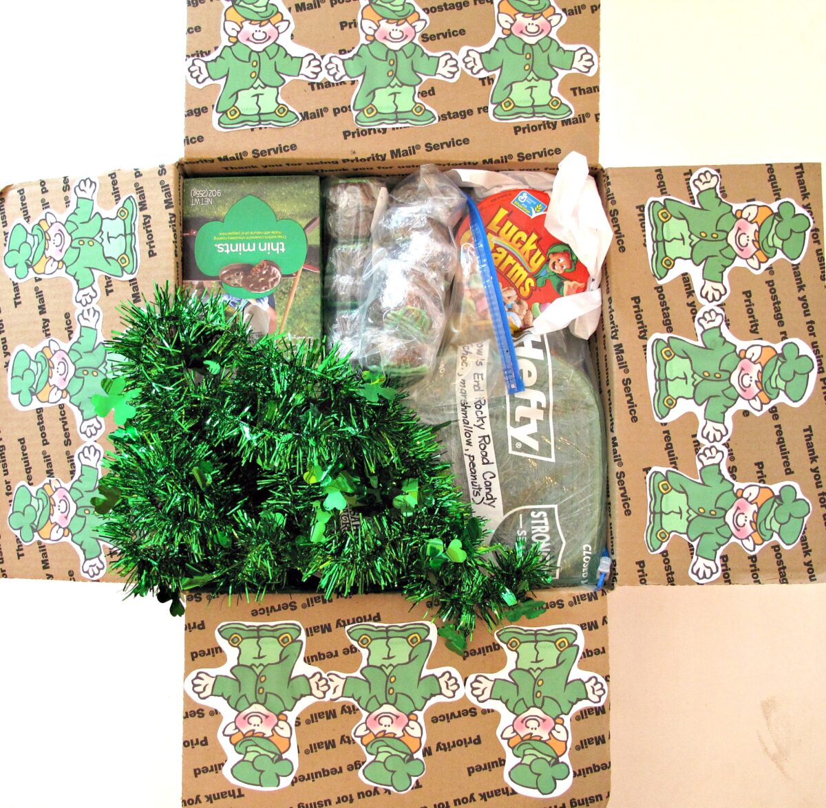 Decorated and filled St. Patrick's Day Care Package with clip art leprechauns on the flaps.