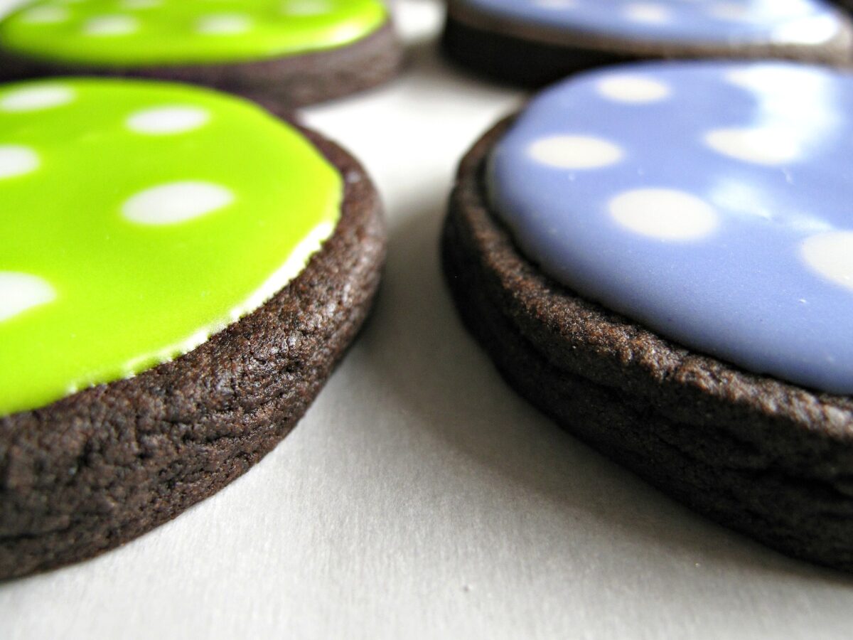 Polka dot chocolate sugar cookies seen from side view showing thickness of cookies and icing.