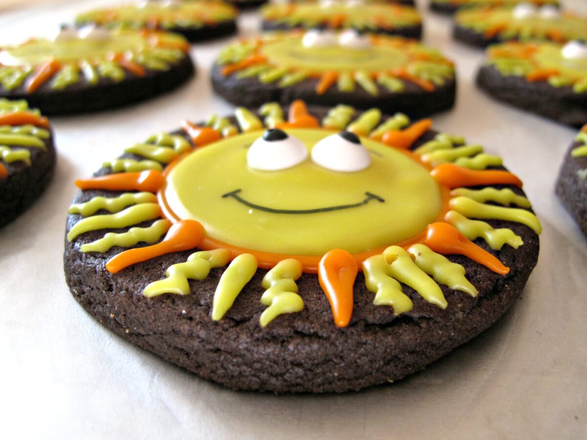 Closeup of smiling sun cookie from the side showing icing thickness.