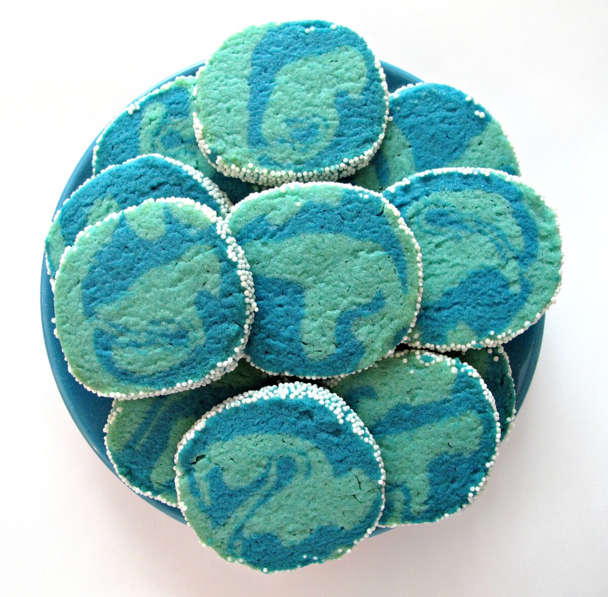 Marbled blue sugar cookies in two shades of blue with nonpareils on the edges.
