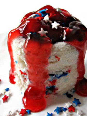 White mug cake with star sprinkles and pie filling.