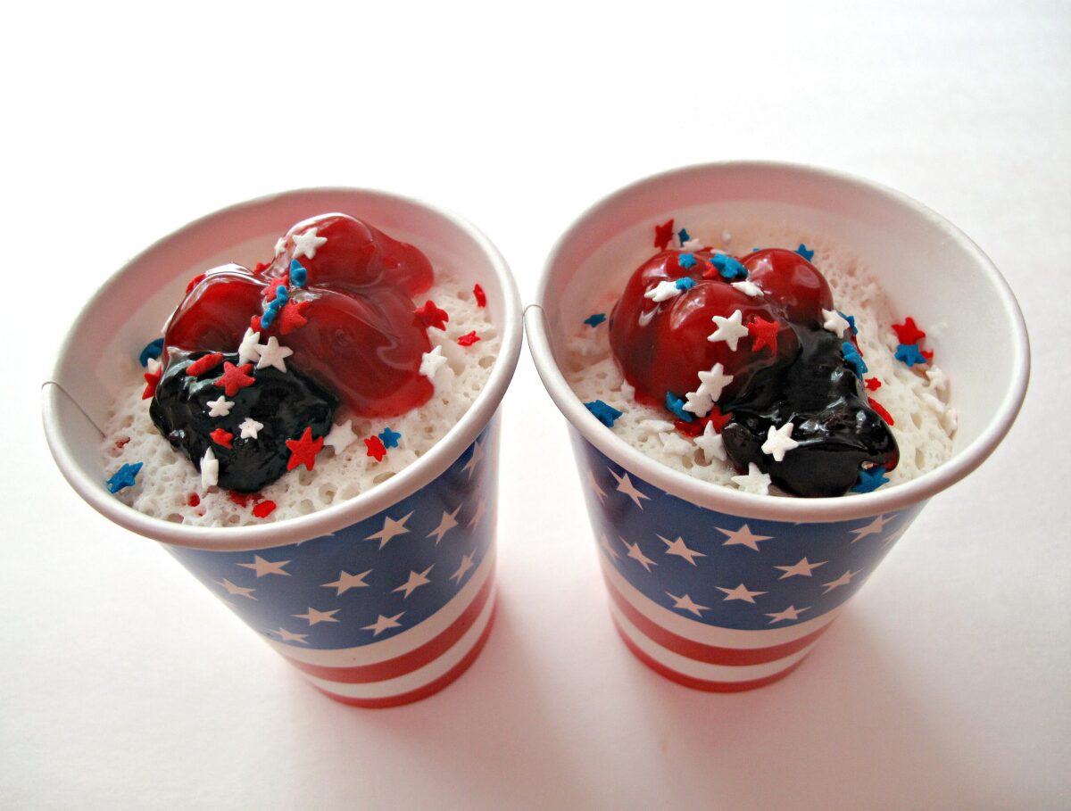 Red, White, and Blueberry Cake  in paper cups topped with cherry and blueberry pie filling.