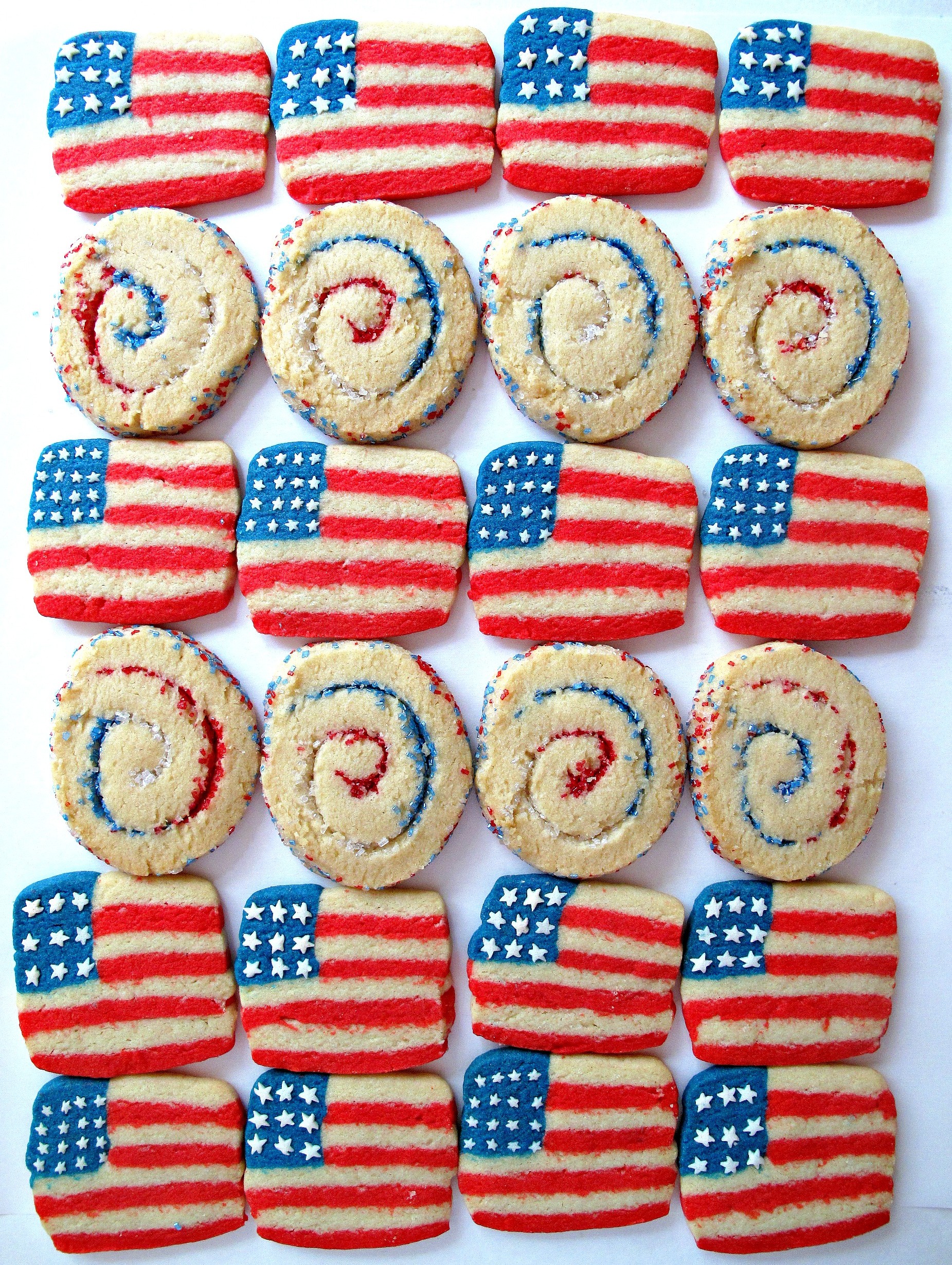 Rows of striped flag cookies and cookies swirled with red, white and blue sugar. 