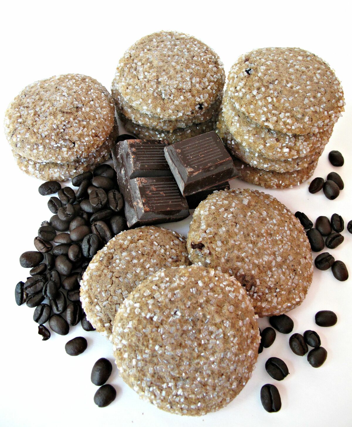 Mocha Sugar Cookies  coated in large crystal sugar next to chocolate squares and espresso beans.